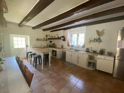 une grande cuisine avec une table et des chaises. dans l'établissement Les Jardins du Stéroulin, au Faouët