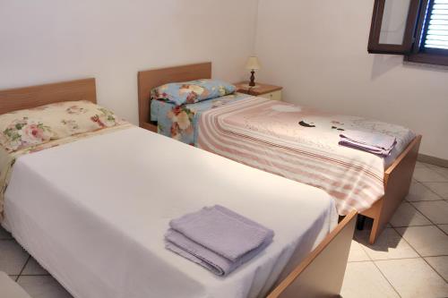 Dos camas en una habitación con toallas. en 2 bedrooms apartement with balcony and wifi at Nughedu Santa Vittoria, en Nughedu Santa Vittoria
