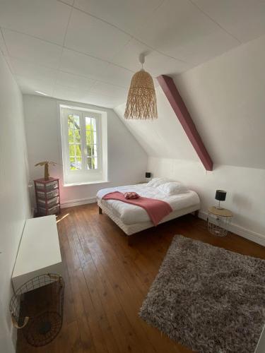 - une chambre mansardée avec un lit et un tapis dans l'établissement Les Jardins du Stéroulin, au Faouët