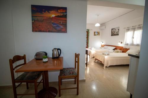 a living room with a table and a bedroom at Harrys bar & apartments in Acharavi