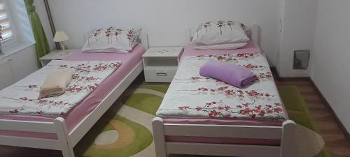 2 camas en una habitación pequeña con almohadas moradas y moradas en Pliva, en Jezero