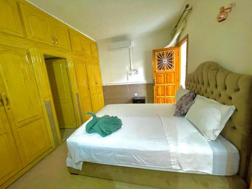 a bedroom with a large white bed with yellow cabinets at Villa Paradis in Marrakech