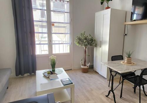 un salon avec une table et une grande fenêtre dans l'établissement 3# Central'Tours VERT - Hypercentre, à Tours