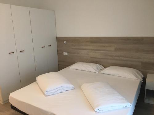 a bedroom with two beds with white pillows at Residence Marina in Riva del Garda