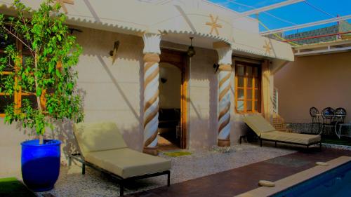 a patio with two chairs and a pool at Villa Paradis in Marrakech