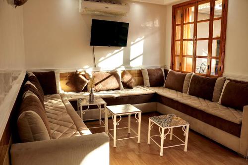 a living room with a couch and a tv at Villa Paradis in Marrakech
