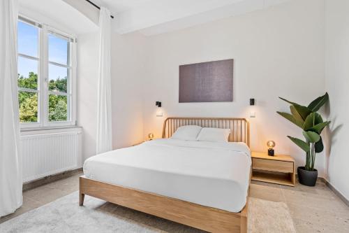 ルクセンブルクにあるClausen Hideaway Modern Accommodationの白いベッドルーム(大型ベッド1台、窓付)