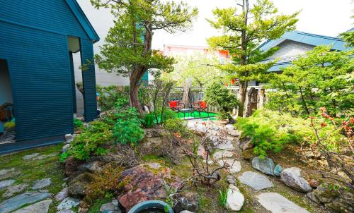 un jardín frente a una casa en furano ski rabi en Furano