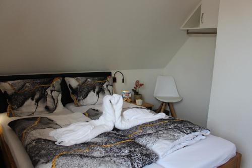a bed covered in white sheets and towels at Haus Deutsche Bucht in Borkum