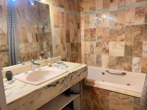 a bathroom with a sink and a tub at Appartement en résidence avec terrasse, piscine in Oyster Pond