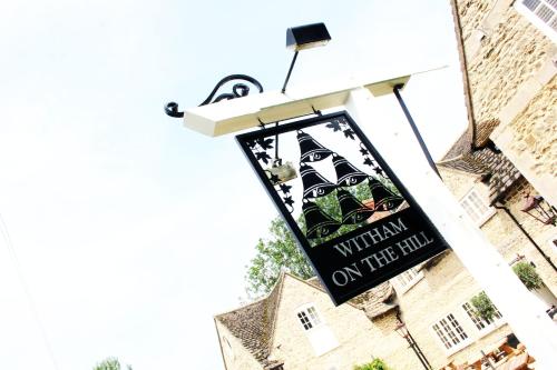 a sign for a restaurant on the side of a building at The Six Bells in Bourne