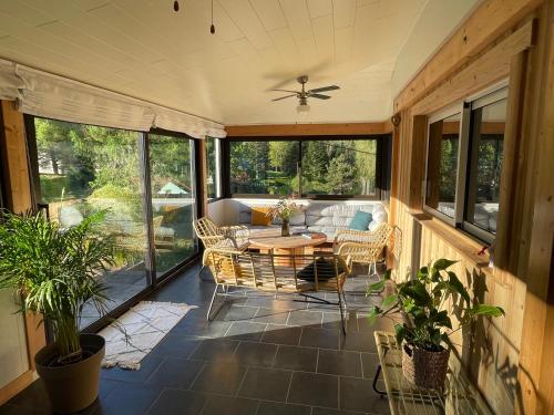 une véranda avec une table et des chaises dans l'établissement Le Balcon de Bramont, à La Bresse