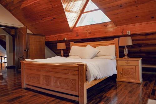 Zavyan Cottage 1 في Nathia Gali: غرفة نوم بسرير كبير مع المنور