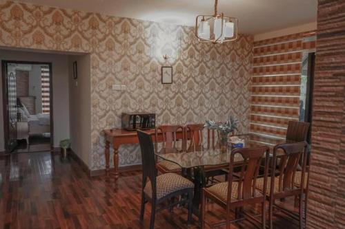 Zavyan Cottage 1 في Nathia Gali: غرفة طعام مع طاولة وكراسي
