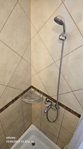 a shower with a shower head in a bathroom at Mirador del Beagle Hosteria in Ushuaia