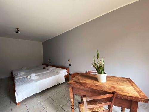 ein Schlafzimmer mit einem Bett und einem Tisch mit einer Topfpflanze in der Unterkunft Agriturismo San Giuliano dei fratelli Giai in Susa