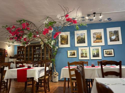 une salle à manger avec des tables et des fleurs sur le mur dans l'établissement Hotel El Refugio de Juanar, à Ojén
