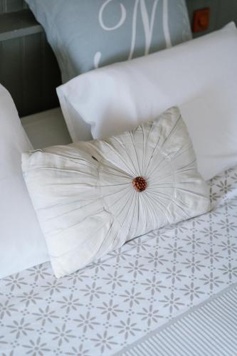 a white pillow sitting on top of a bed at Les Glycines de Monchy- Chambres d'hôtes in Monchy-Humières