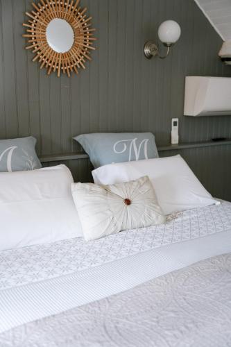 a bedroom with a bed with white sheets and a mirror at Les Glycines de Monchy- Chambres d'hôtes in Monchy-Humières