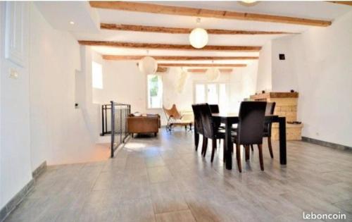 a dining room with a table and black chairs at Agréable maison de village in Laudun