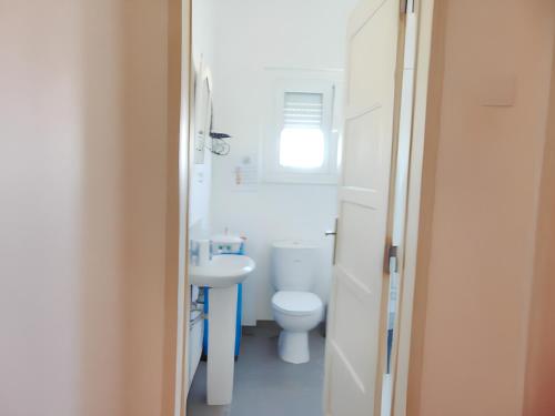a bathroom with a white toilet and a sink at 3 bedrooms apartement with city view shared pool and enclosed garden at Feijo 5 km away from the beach in Almada