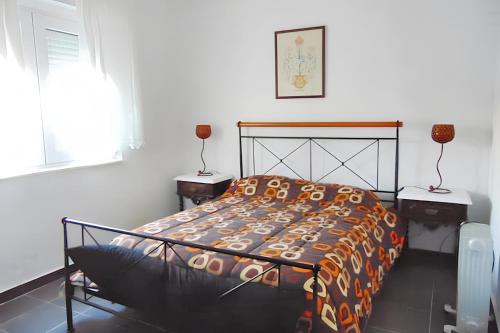 a bedroom with a bed and two tables and a window at 2 bedrooms apartement with shared pool enclosed garden and wifi at Almada 5 km away from the beach in Almada