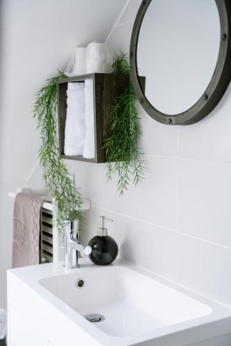 a bathroom with a white sink and a mirror at Les Glycines de Monchy- Chambres d'hôtes in Monchy-Humières