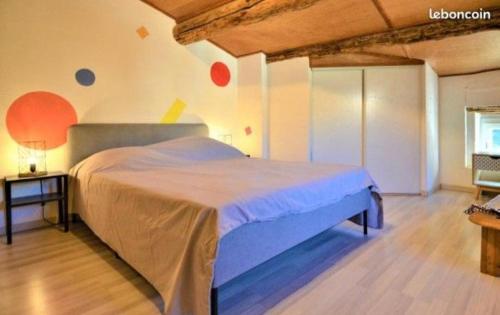 a bedroom with a large bed in a room at Agréable maison de village in Laudun