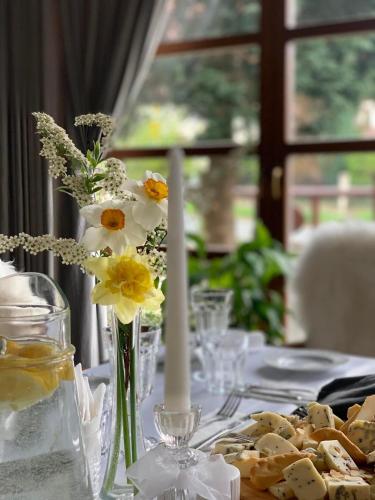 a table with a vase of flowers and cookies at Hotel Promyk Wellness & Spa in Karpacz