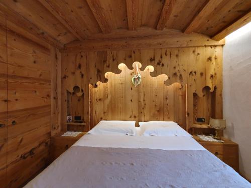 a bedroom with a bed in a wooden room at Daniela Apartment in Cortina dʼAmpezzo