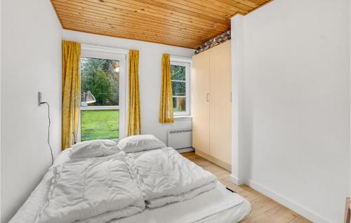 a bed in a room with a large window at Stunning Home In Rm With Wifi in Rømø Kirkeby