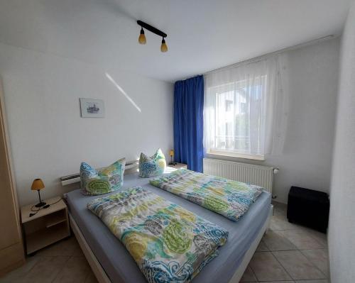 ツィノヴィッツにあるFerienquartier Müllerのベッドルーム1室(ベッド1台、青いカーテン付きの窓付)