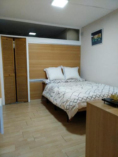 - une chambre avec un lit et un mur en bois dans l'établissement Joli appartement 3 personne, à Hendaye