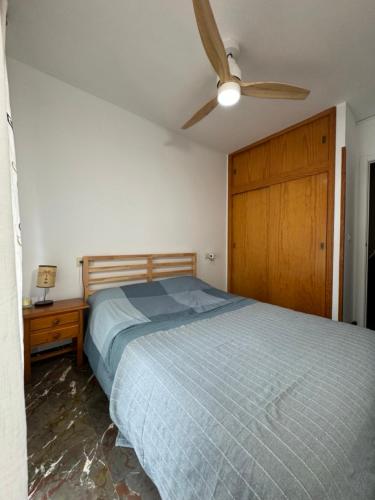 Un dormitorio con una cama y un ventilador de techo. en Vista & Calma Castell de Ferro, en Castell de Ferro