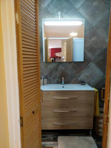 une salle de bain avec un lavabo et un miroir dans l'établissement Joli appartement 3 personne, à Hendaye