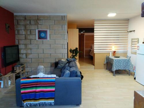 un salon avec un canapé bleu et une table dans l'établissement Joli appartement 3 personne, à Hendaye