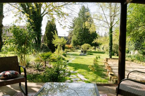 a view of a garden from the porch of a house at Les Glycines de Monchy- Chambres d'hôtes in Monchy-Humières