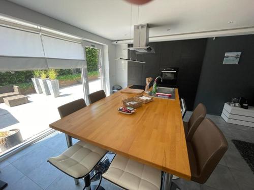 a dining room with a wooden table and chairs at Appartement 5 personnes avec accès piscine in Thyle