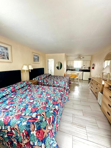 a bedroom with a large bed with a colorful blanket at Sea Kist Motel in Wildwood