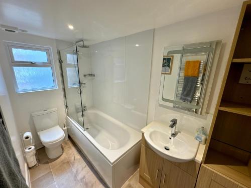 a bathroom with a sink and a tub and a toilet at Struan House in Blairgowrie