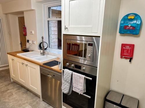 a kitchen with a sink and a microwave at Struan House in Blairgowrie
