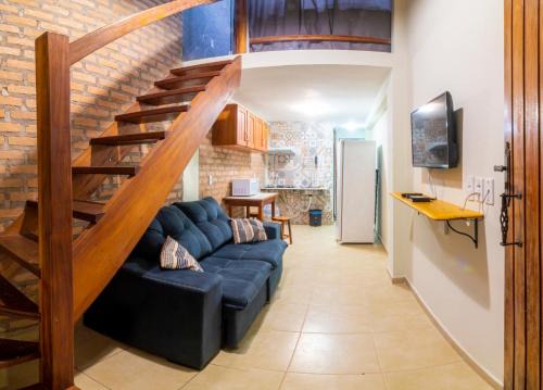 a living room with a blue couch and a staircase at Pousada Nativos Lençois in Lençóis