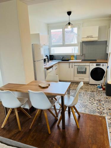 - une cuisine avec une table en bois et des chaises blanches dans l'établissement Fontaine blanche Besançon, à Besançon