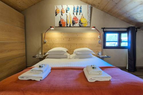 a bedroom with a large bed with towels on it at La Maison De Pierre in Langeac