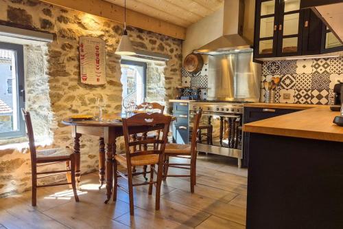 une cuisine avec une table et des chaises dans une pièce dans l'établissement La Maison De Pierre, à Langeac