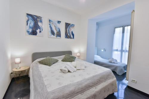 una camera bianca con un grande letto con due cuscini di Welcome Varigotti - Civico53 a Varigotti