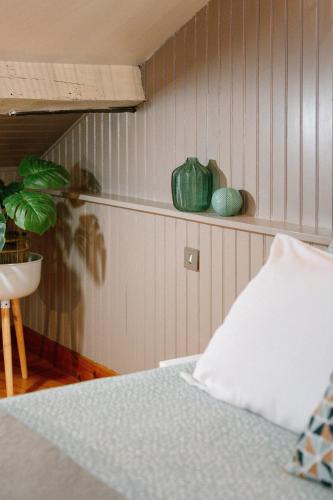 a bedroom with a bed and a plant on a shelf at Les Glycines de Monchy- Chambres d'hôtes in Monchy-Humières