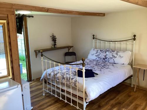 a bedroom with a bed with a metal frame at Cabin 4 in Kent