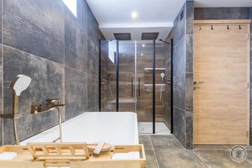 a bathroom with a bath tub and a shower at Le Jardin De Marie in Pontorson