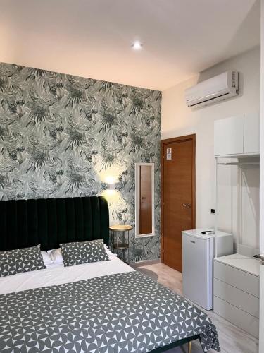 sypialnia z łóżkiem i ścianą z tapetą w obiekcie Costantino Home w mieście Pompeje